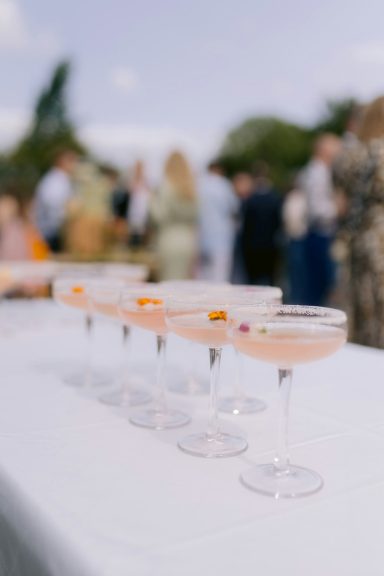 Cocktails in klassischen Gläsern, dekoriert mit Früchten, auf einem Tisch arrangiert.