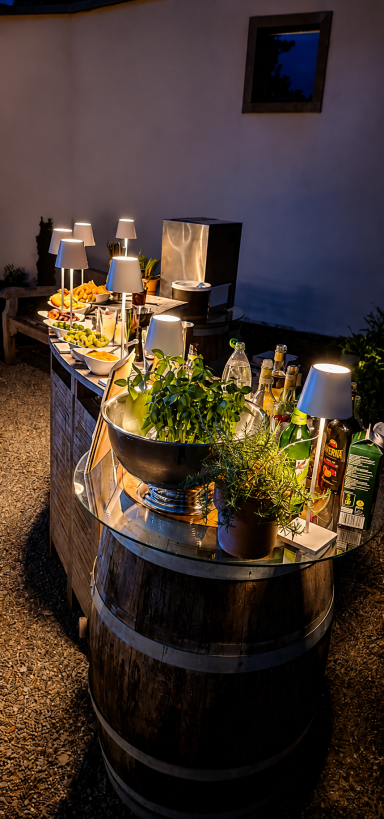 Ein dekorierter Cocktail Tisch mit Lebensmitteln und Getränken auf einem Weinfass.